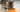 A cat eating Calibra dry cat food out of an orange food bowl